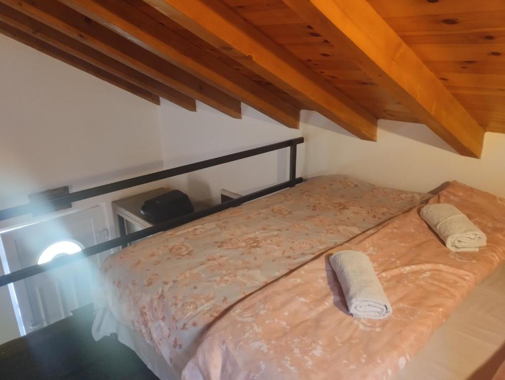 a bed in a room with wooden ceilings at WOODSTONE APARTMAN in Podgorica