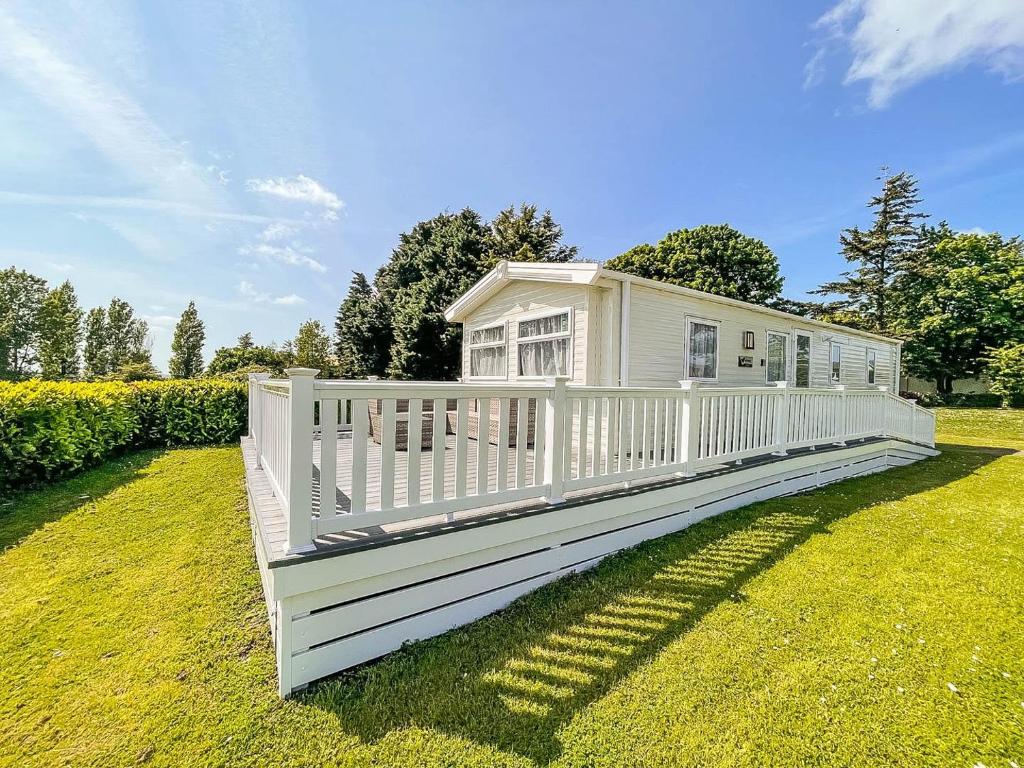 mały biały dom z białym płotem w obiekcie Beautiful 6 Berth Caravan With Decking In Norfolk Ref 89001mv w mieście Belton