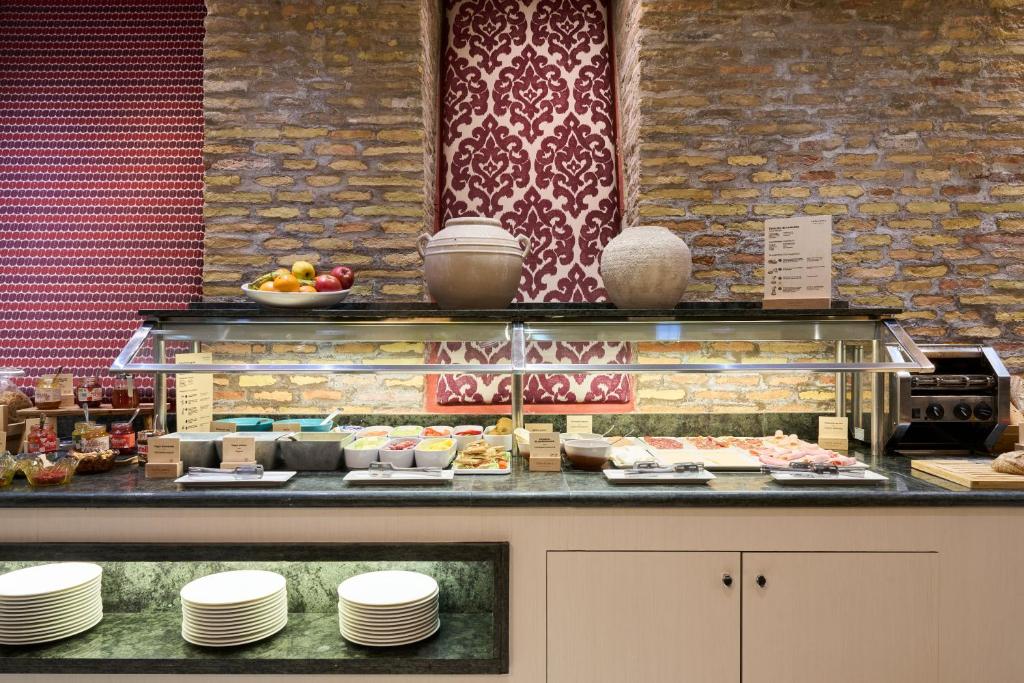 a buffet with plates and food on a counter at Catalonia El Pilar in Zaragoza