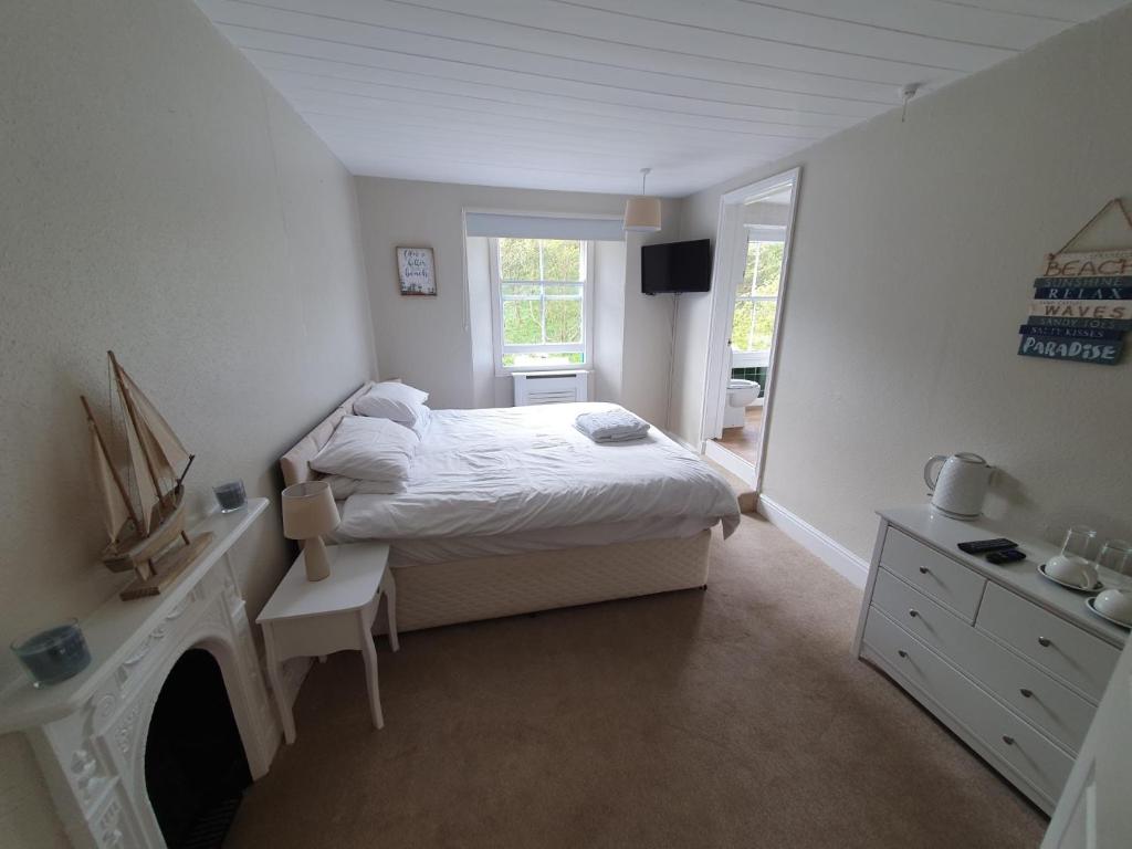 a small bedroom with a bed and a fireplace at The Ship Inn in Truro