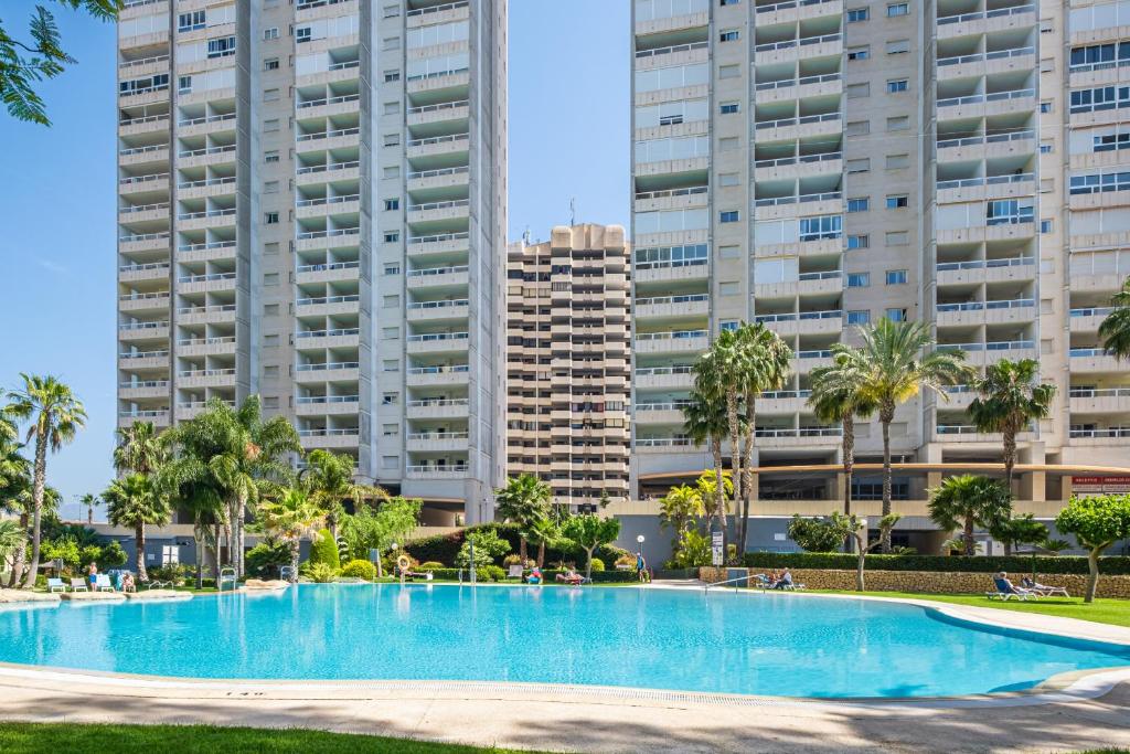 Gemelos 22 Resort Apartment 3-1C Levante Beach في بنيدورم: مسبح امام بعض المباني الطويلة