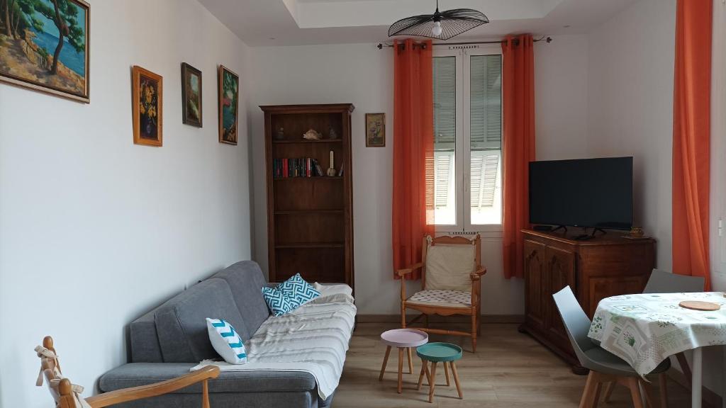 un salon avec un canapé et une télévision dans l'établissement MENTON A 2 pas des plages de sable et du centre ville beau 3 pièces pour 3 personnes, à Menton
