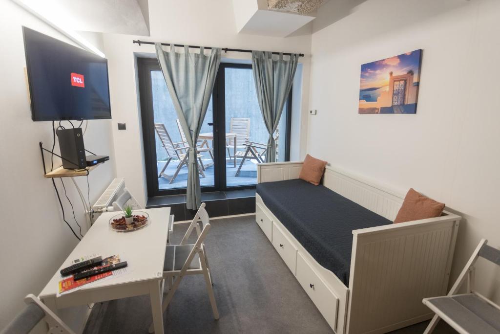 een slaapkamer met een bed, een bureau en een tafel bij Peaceful Basement Apartment with Terrace & free GYM in Boedapest