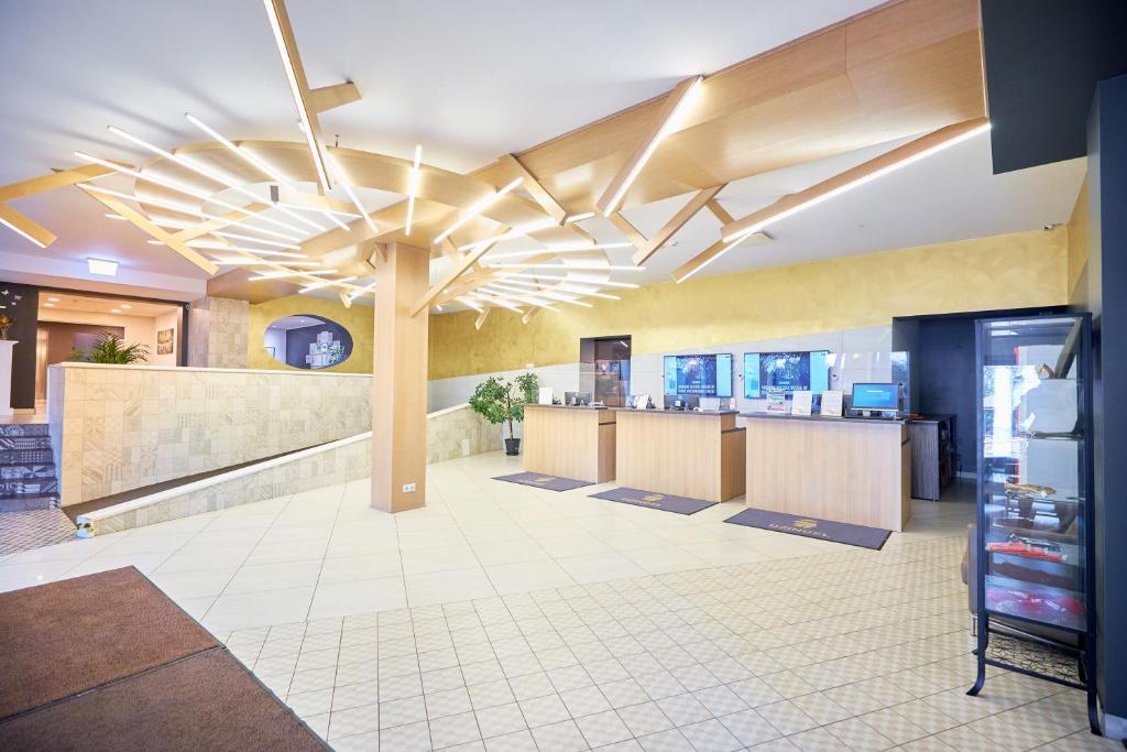 un vestíbulo con una cafetería con un techo grande en Hotel Dzingel en Tallin