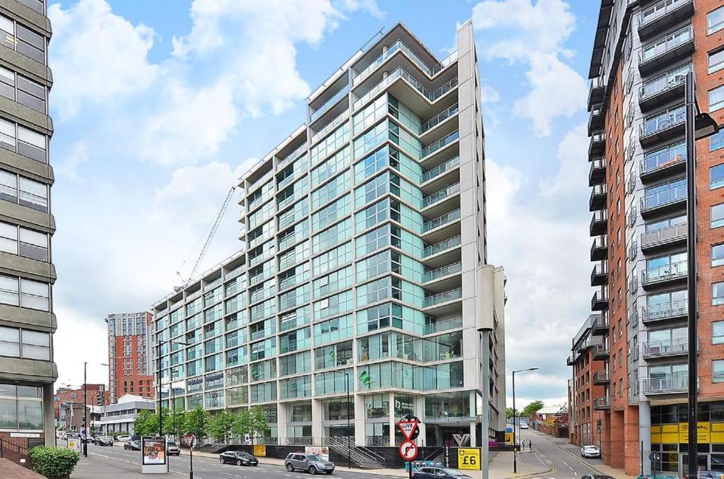 a tall building with glass windows on a city street at A Home in the City. in Sheffield