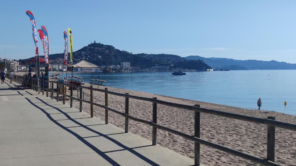 a beach with a fence next to a body of water at Casa junto al mar in Blanes