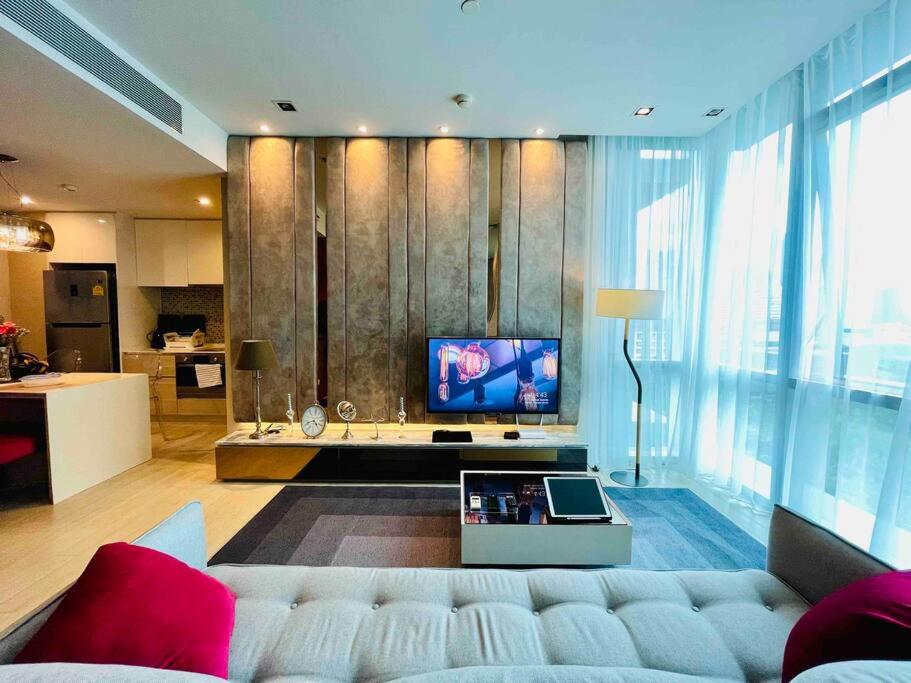 a living room with a white couch and a television at Luxurious in Prime Area Bangkok (PickupService) in Bangkok