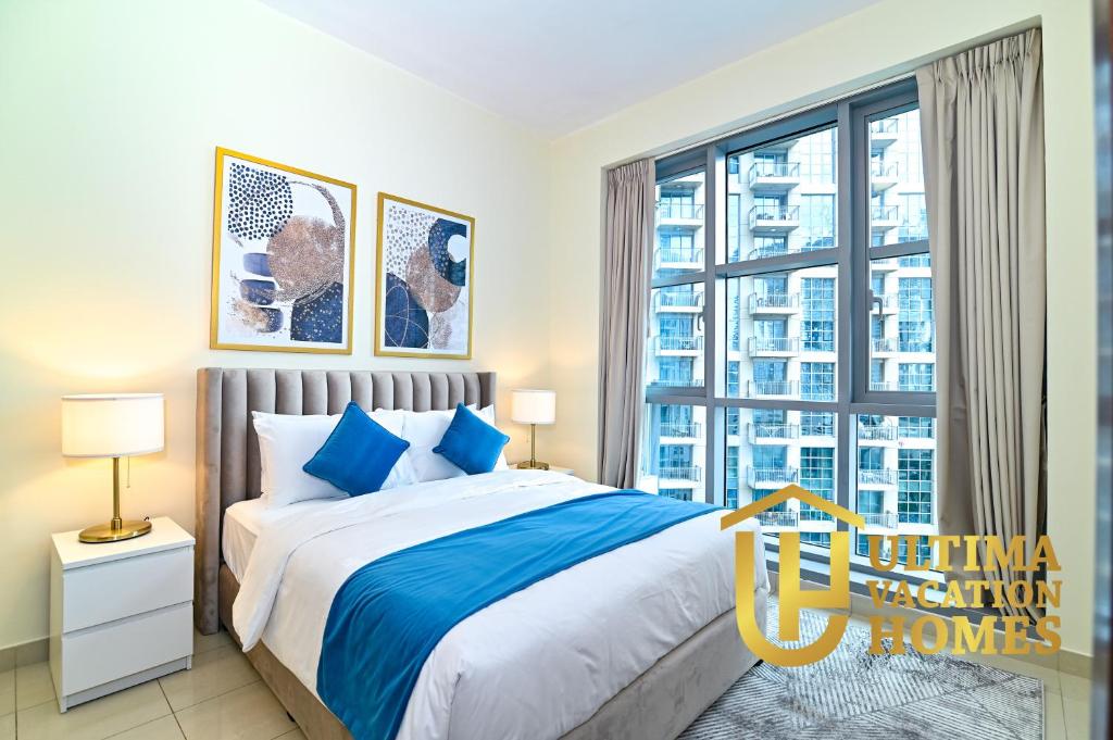a bedroom with a bed and a large window at Stylish 1BR-Next to Dubai Mall in Standpoint B in Dubai