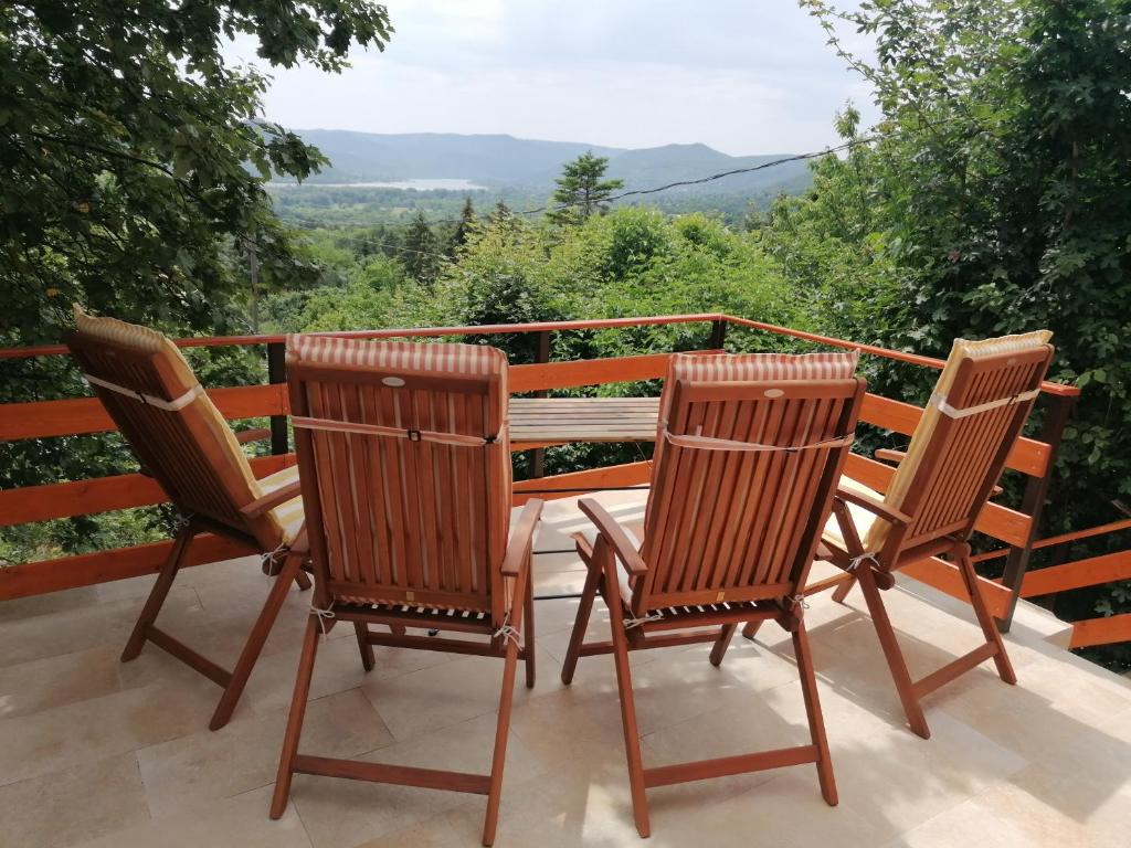 Duas cadeiras e uma mesa numa varanda com vista em Barkóca és Szépkilátás Vendégház / Cabin em Kismaros