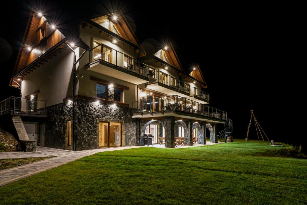 a large house at night with lights on it at Janasiówka in Kamesznica