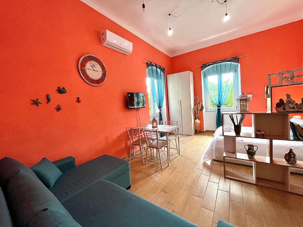 a living room with a blue couch and an orange wall at Cà del Vins - Studio Flat in La Spezia in La Spezia