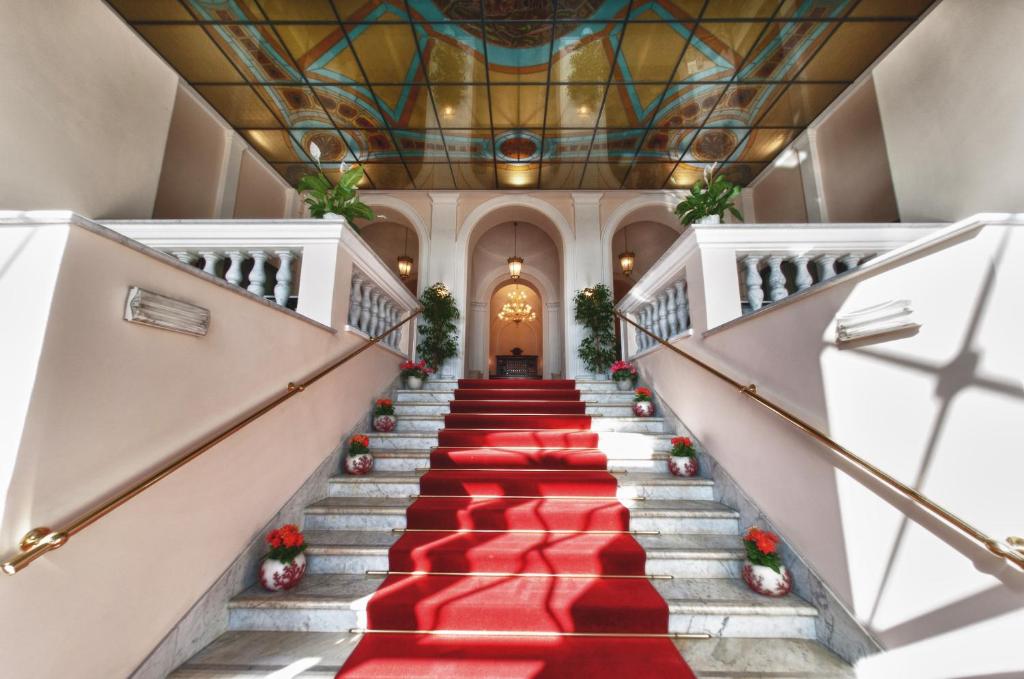 a staircase with red carpeting and a ceiling at Hotel San Giorgio in Civitavecchia