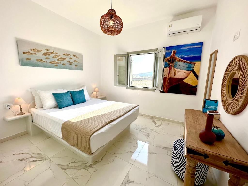 a white bedroom with a bed and a table at Santana Apartments in Perivolos