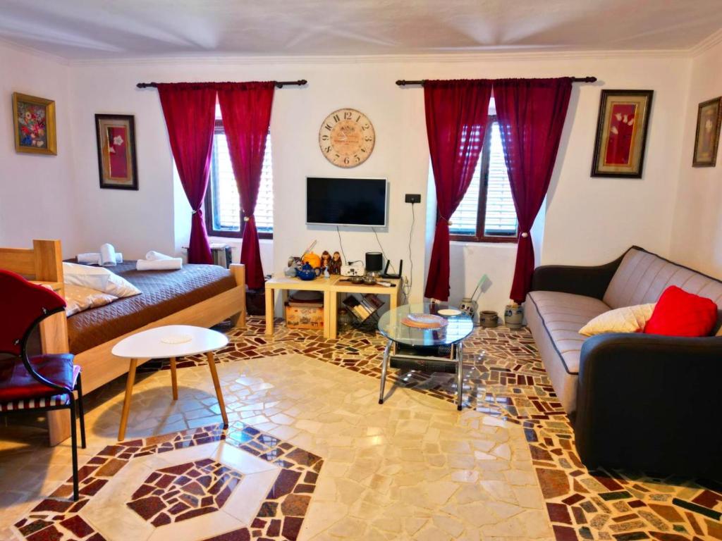 a living room with red curtains and a couch at Dabanović House in Virpazar