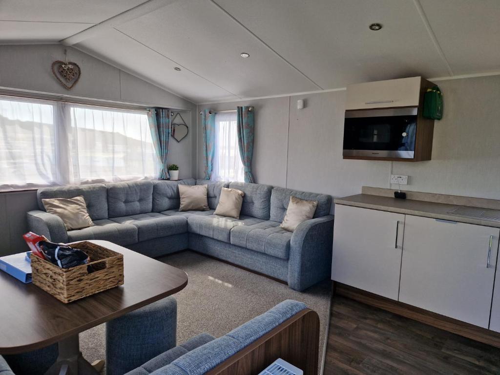 a living room with a couch and a table at The fleet retreat in Weymouth