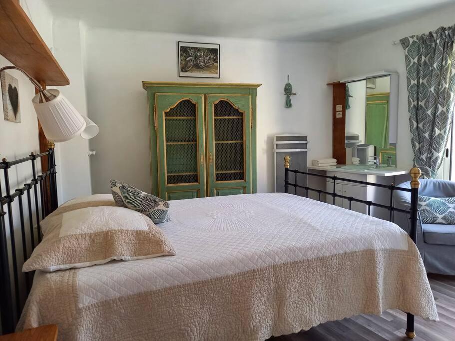 una camera con un grande letto e una cucina di Comps sur Artuby, le tilleul et le four, Jabron a Comps-sur-Artuby