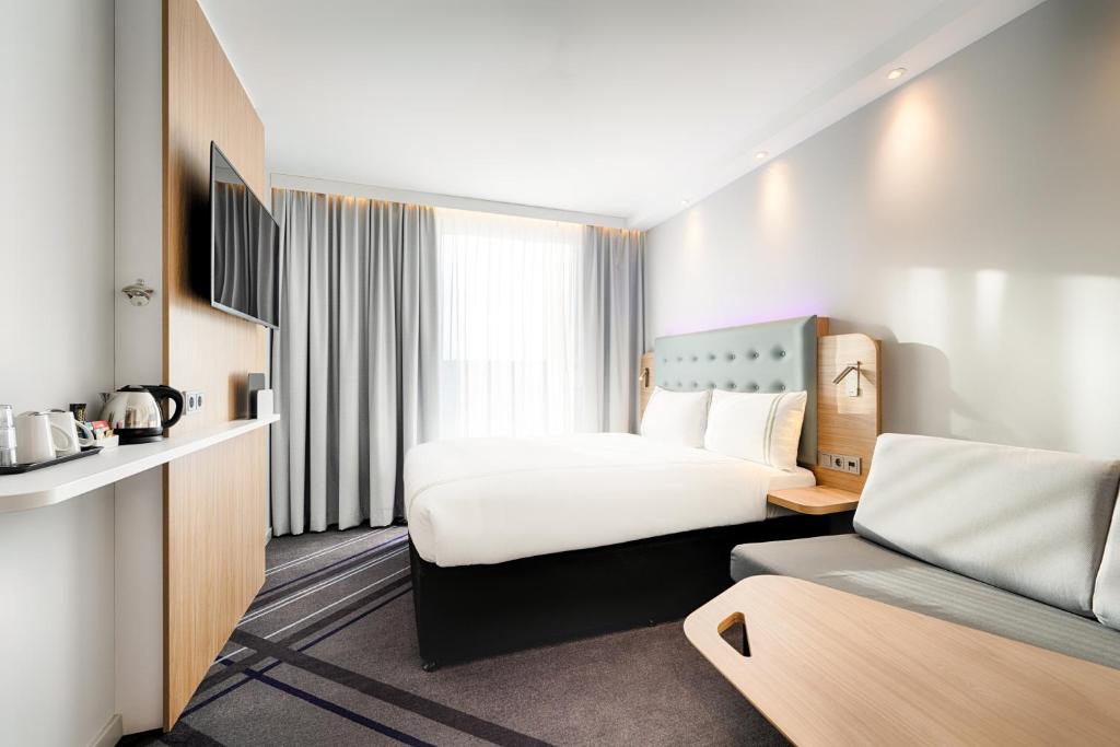 une chambre d'hôtel avec un grand lit et une chambre avec dans l'établissement Premier Inn Leipzig City Hahnekamm, à Leipzig
