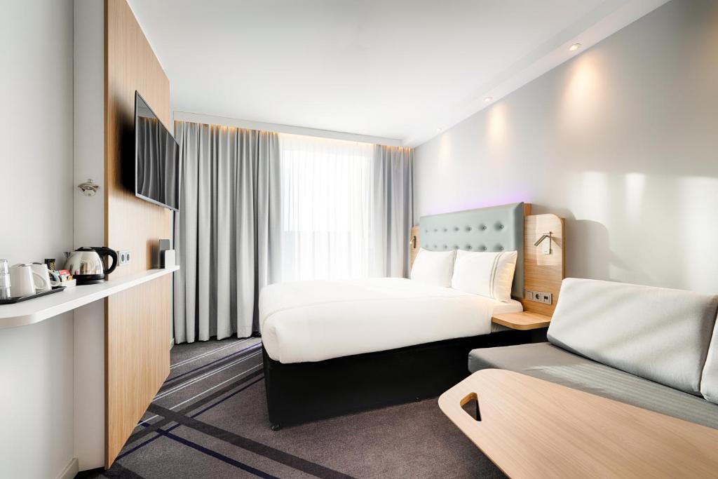 a hotel room with a large bed and a room with at Premier Inn Leipzig City Hahnekamm in Leipzig