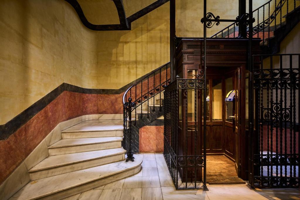 a staircase in a building with a wrought iron railing at Catalonia El Pilar in Zaragoza