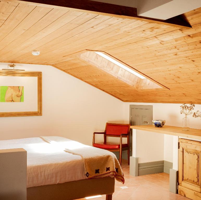 a bedroom with a bed and a wooden ceiling at Casa do Lado in Vila Nova de Milfontes