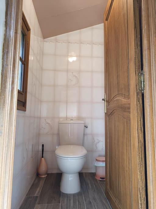 a bathroom with a toilet and a wooden door at Cadre d&#39;exception in Orange