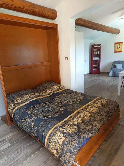 a bed with a wooden headboard in a room at Cadre d&#39;exception in Orange