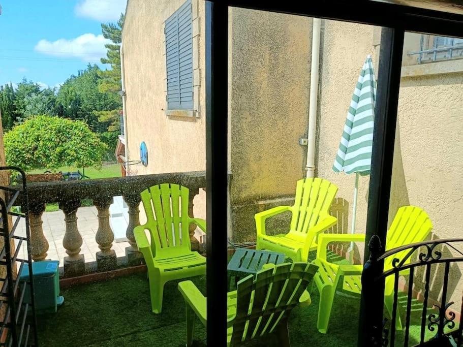 three yellow chairs and an umbrella on a balcony at Cadre d&#39;exception in Orange