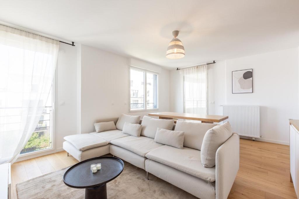 un salon avec un canapé blanc et une table dans l'établissement Full House By Plaza, à Chessy