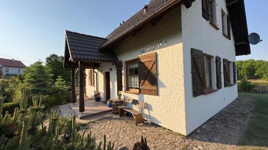 a building with a bench in front of it at Dom w sercu Kaszub in Parchowo