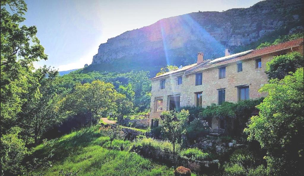 un edificio en una colina con un arco iris en el fondo en Chasteuil Locations Studio, en Castellane