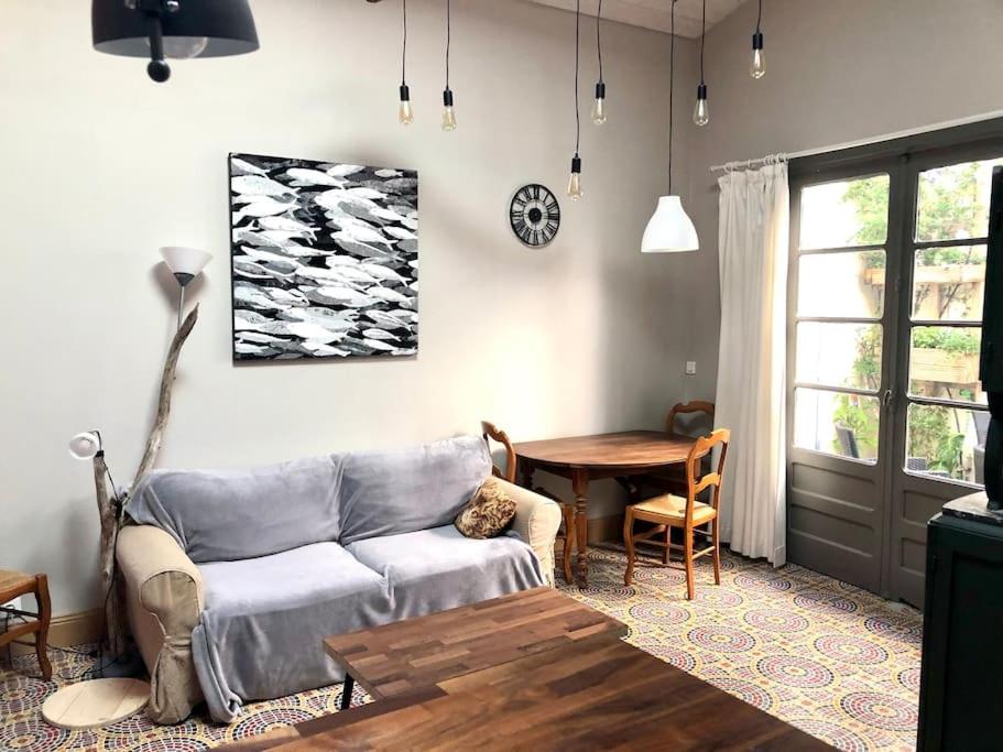 Grand studio indépendant في Paulhan: غرفة معيشة مع أريكة وطاولة
