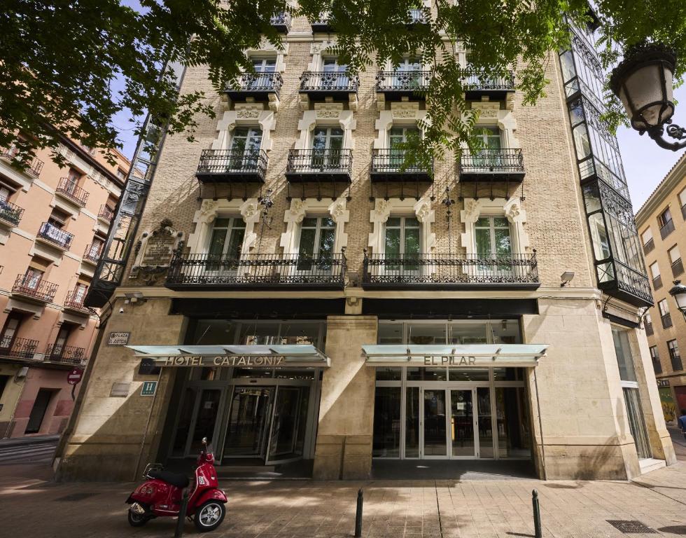 a red scooter parked in front of a building at Catalonia El Pilar in Zaragoza