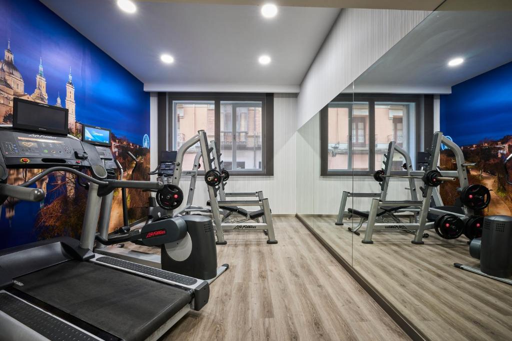 a gym with two treadmills and two tread machines at Catalonia El Pilar in Zaragoza