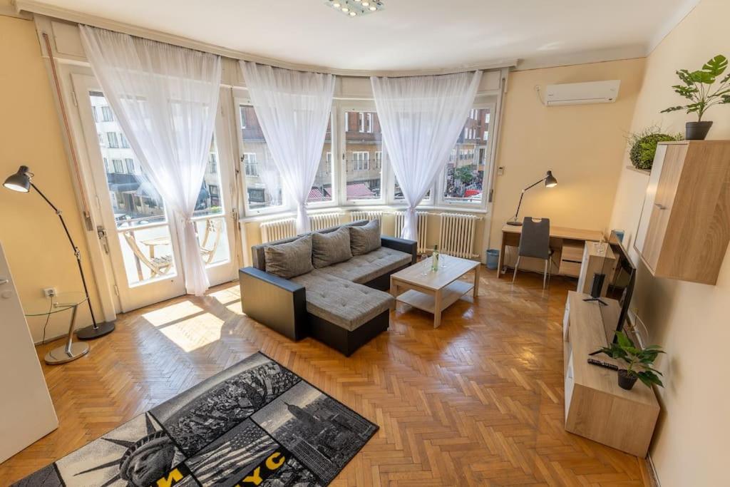 a living room with a couch and a large window at Best Location, Family friendly Panorama view by NW in Budapest