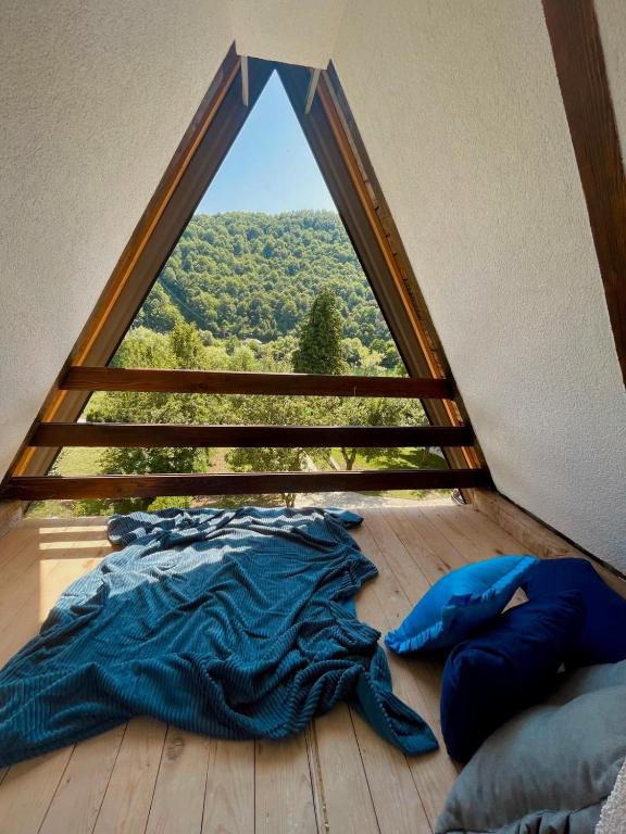 Bett in einem Zimmer mit einem großen Fenster in der Unterkunft Cozy Weekend House Zaid in Bihać