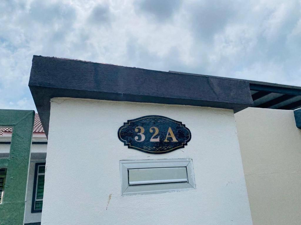 une horloge sur le côté d'un bâtiment blanc dans l'établissement Warm Smile Homestay, 