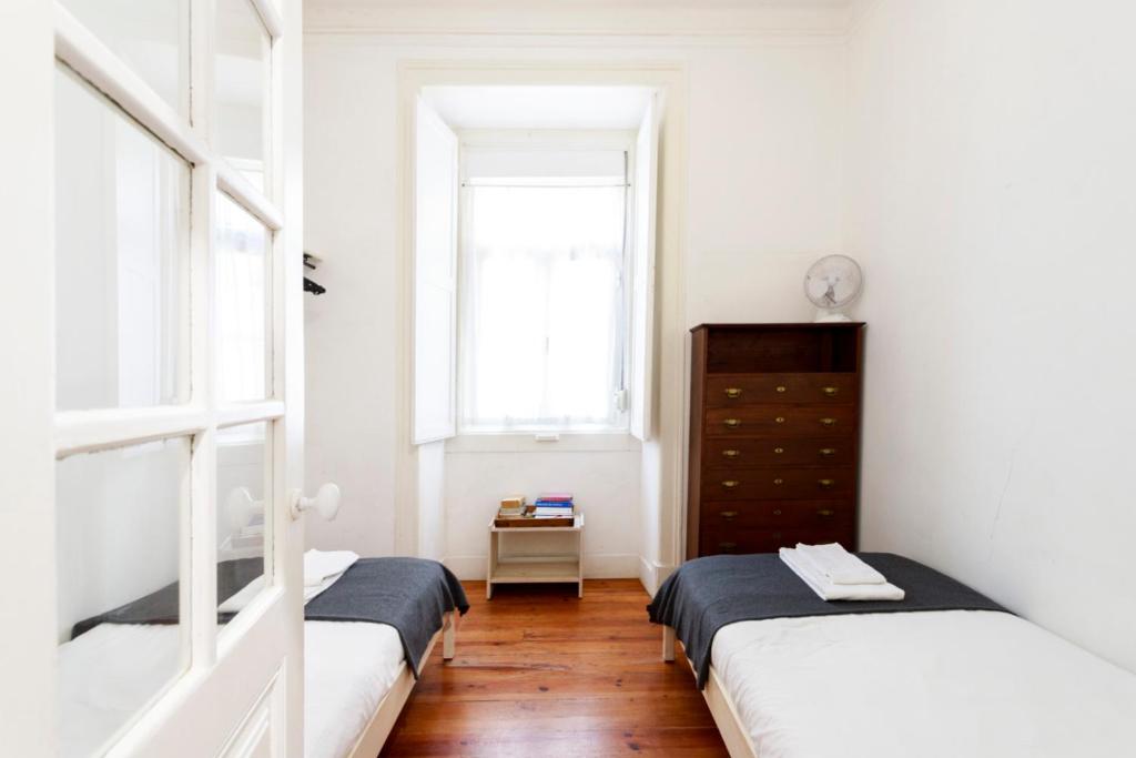 duas camas num quarto com duas janelas em Historical Apartment em Lisboa