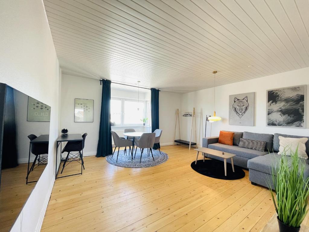 uma sala de estar com um sofá e uma mesa em aday - Modern charming apartment in Noerresundby em Nørresundby