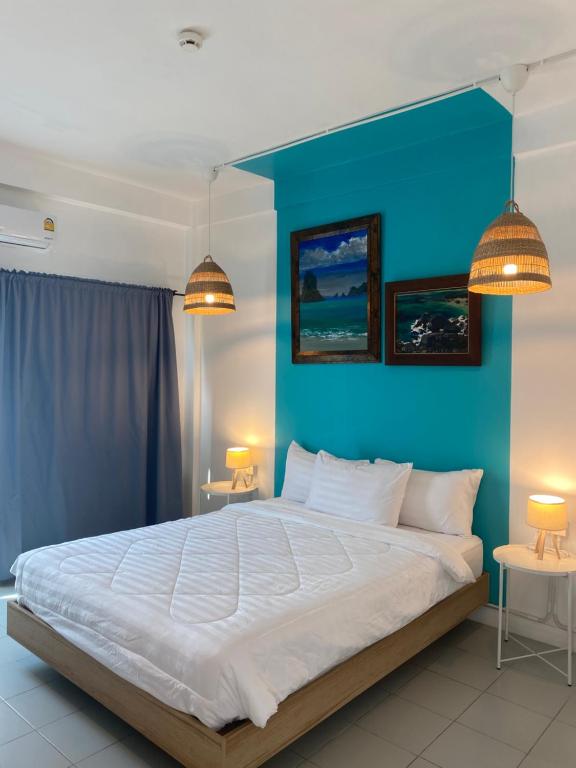 a bedroom with a large bed with a blue wall at Baan Suandao Wat Arun in Bangkok