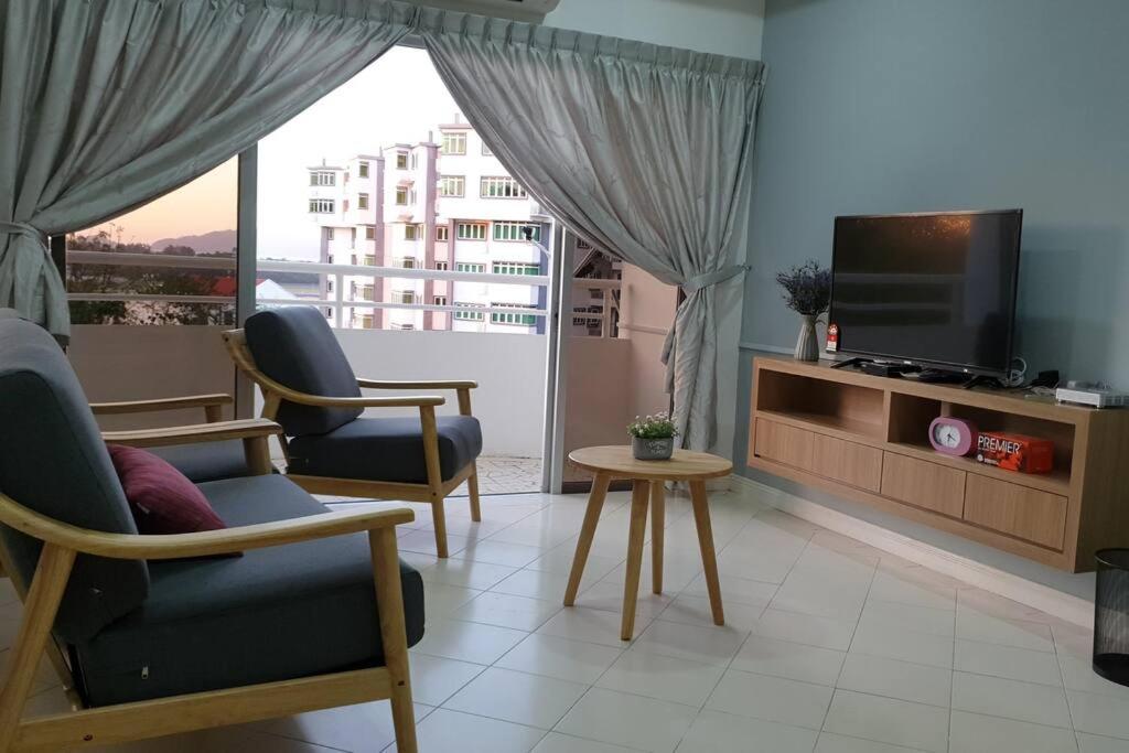 sala de estar con 2 sillas y TV de pantalla plana en 2. Luxury Kristal Condo 2 丹绒亚路高級市中心住宅 en Kapayan