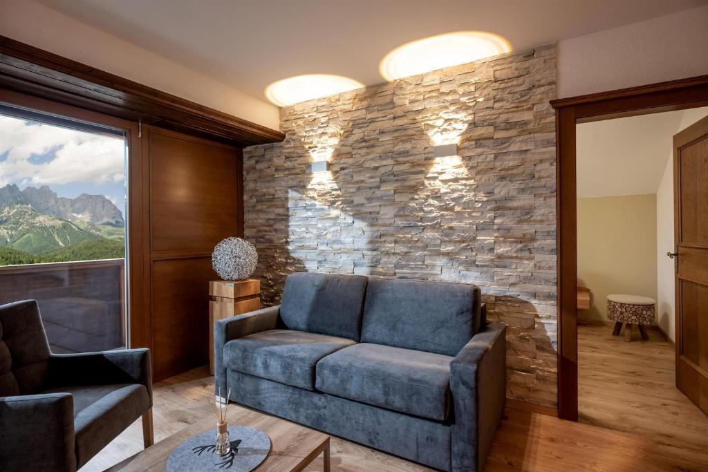 uma sala de estar com um sofá e uma parede de pedra em Ellmauer Auszeit em Ellmau
