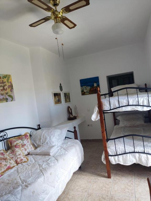 a bedroom with two bunk beds and a ceiling fan at KATKA Karavas in Kythira