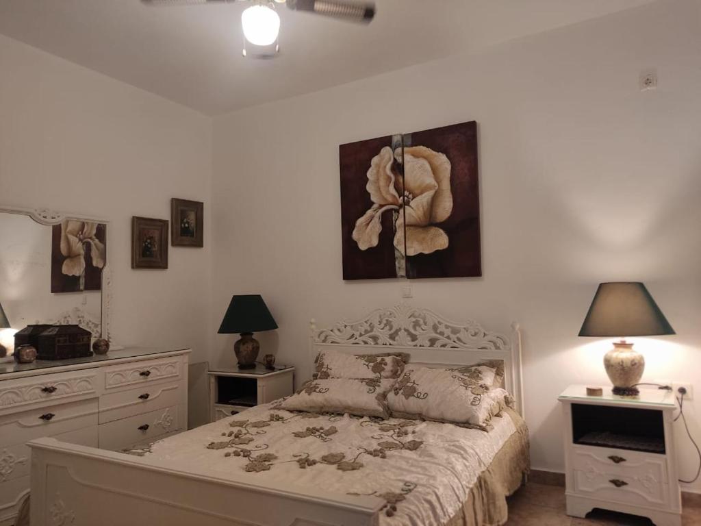 a bedroom with a bed and two lamps and a dresser at KATKA Karavas in Kythira