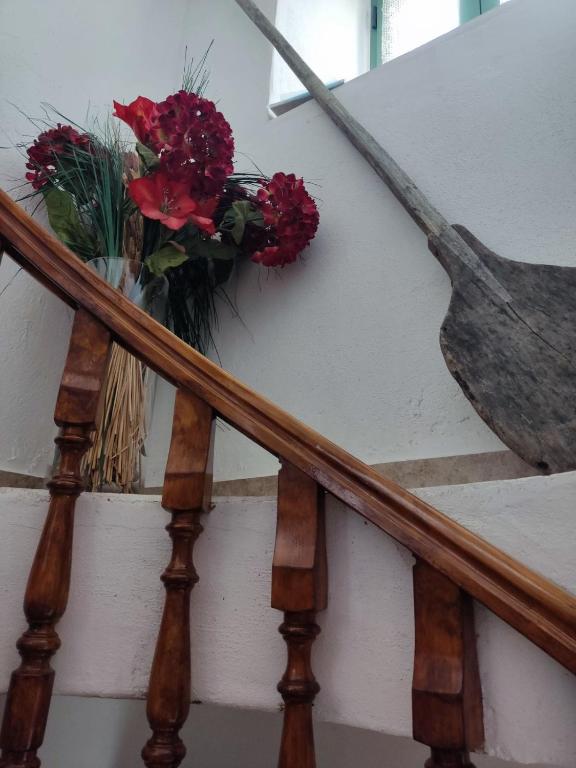 a vase of flowers sitting on a stair case at KATKA Karavas in Kythira