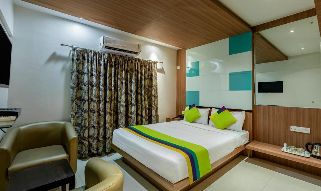 バンガロールにあるItsy Hotels Hiland Suitesのベッドと机と椅子のある寝室