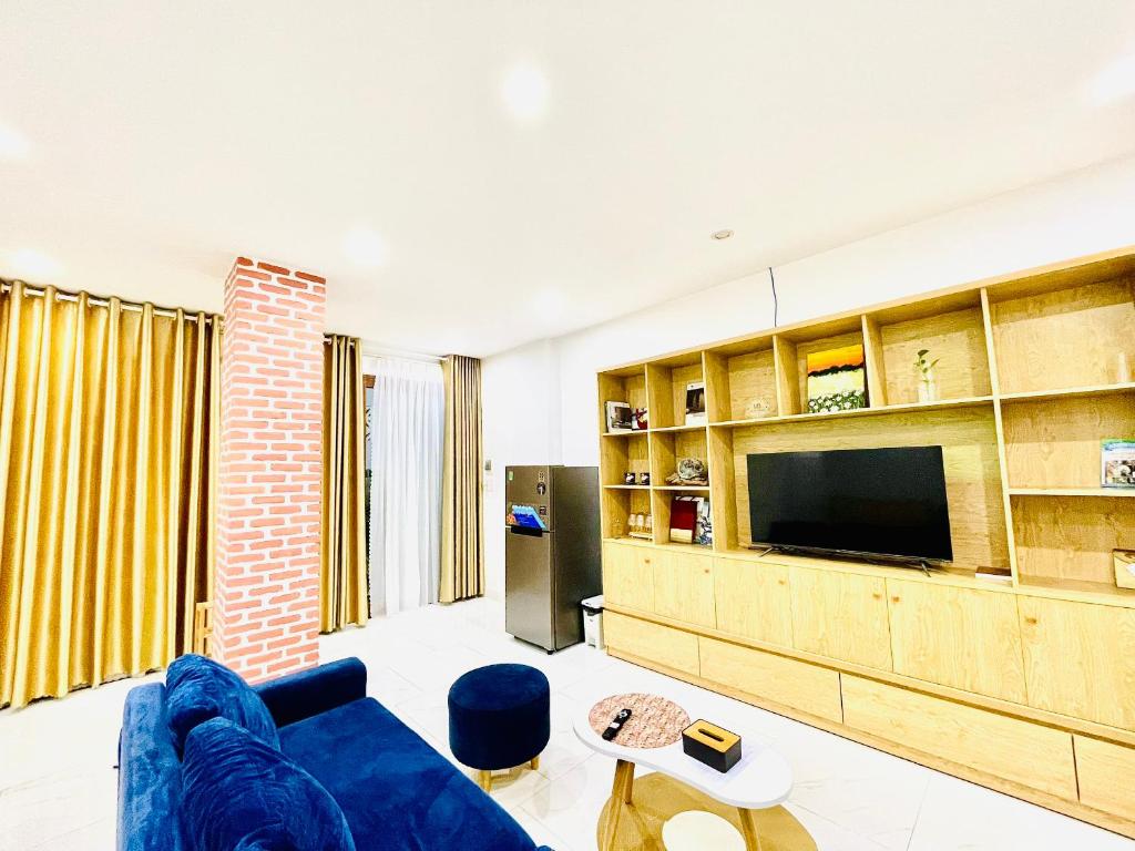 a living room with a blue couch and a tv at TINA HOUSE Apartment in Da Nang