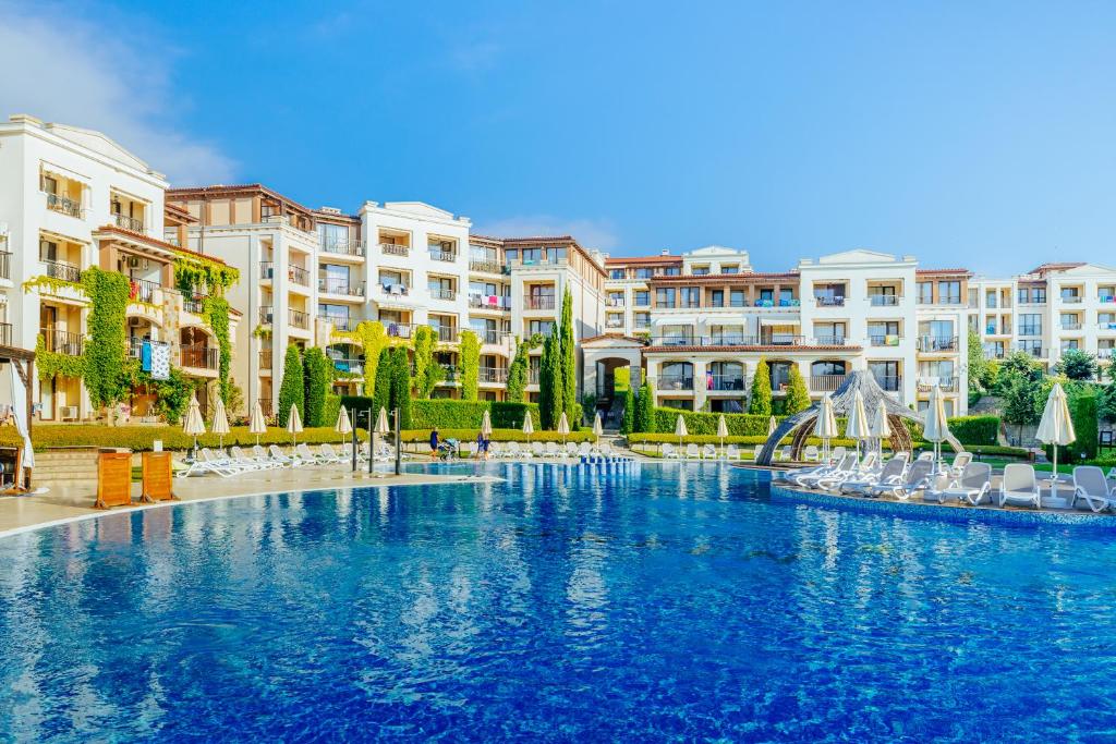 uma grande piscina com cadeiras e edifícios em Green Life Apartments Sozopol em Sozopol