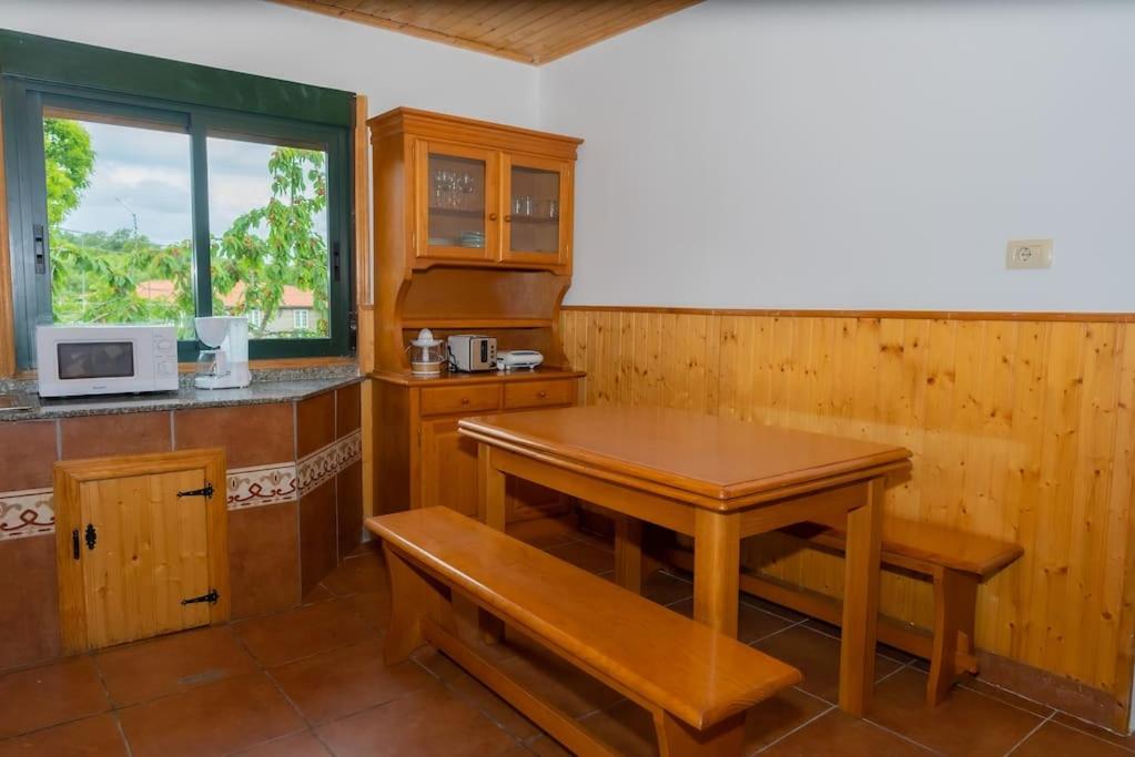 - une cuisine avec une table en bois et un four micro-ondes dans l'établissement Refugio do Sil, Magia y Encanto en la Ribera Sacra, 
