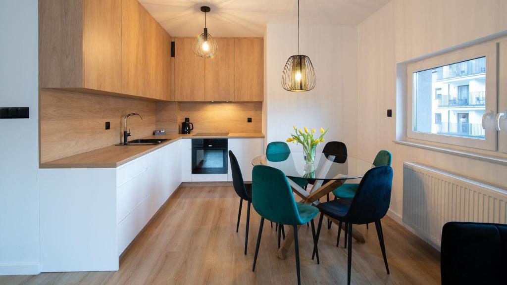 a kitchen and dining room with a table and chairs at Apartament na Spokojnej in Wisła