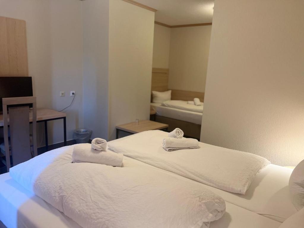 1 dormitorio con 2 camas blancas y toallas. en Altes Sudhaus en Aschaffenburg